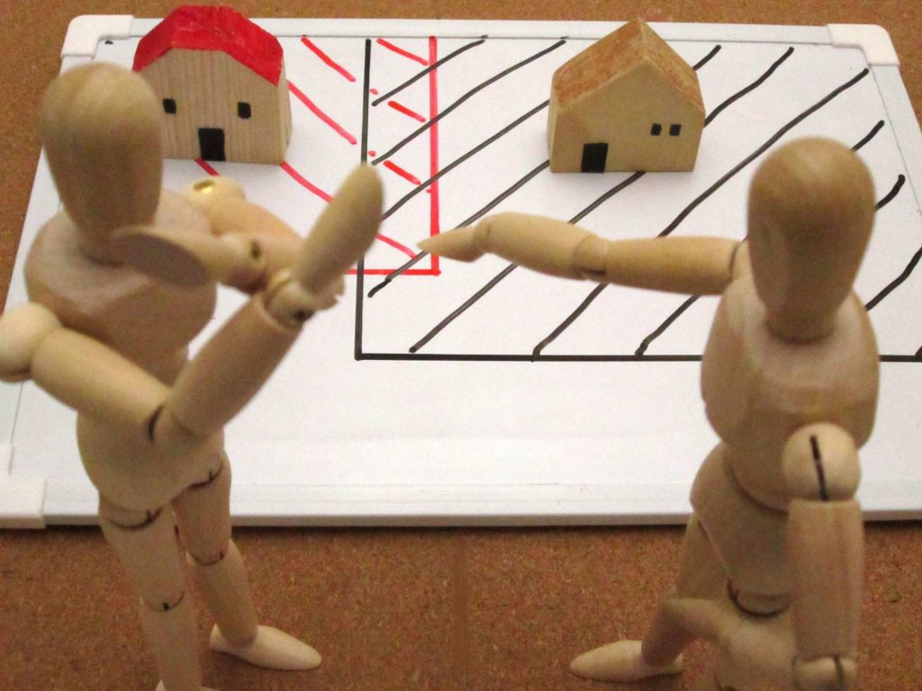 Wooden people fighting over property