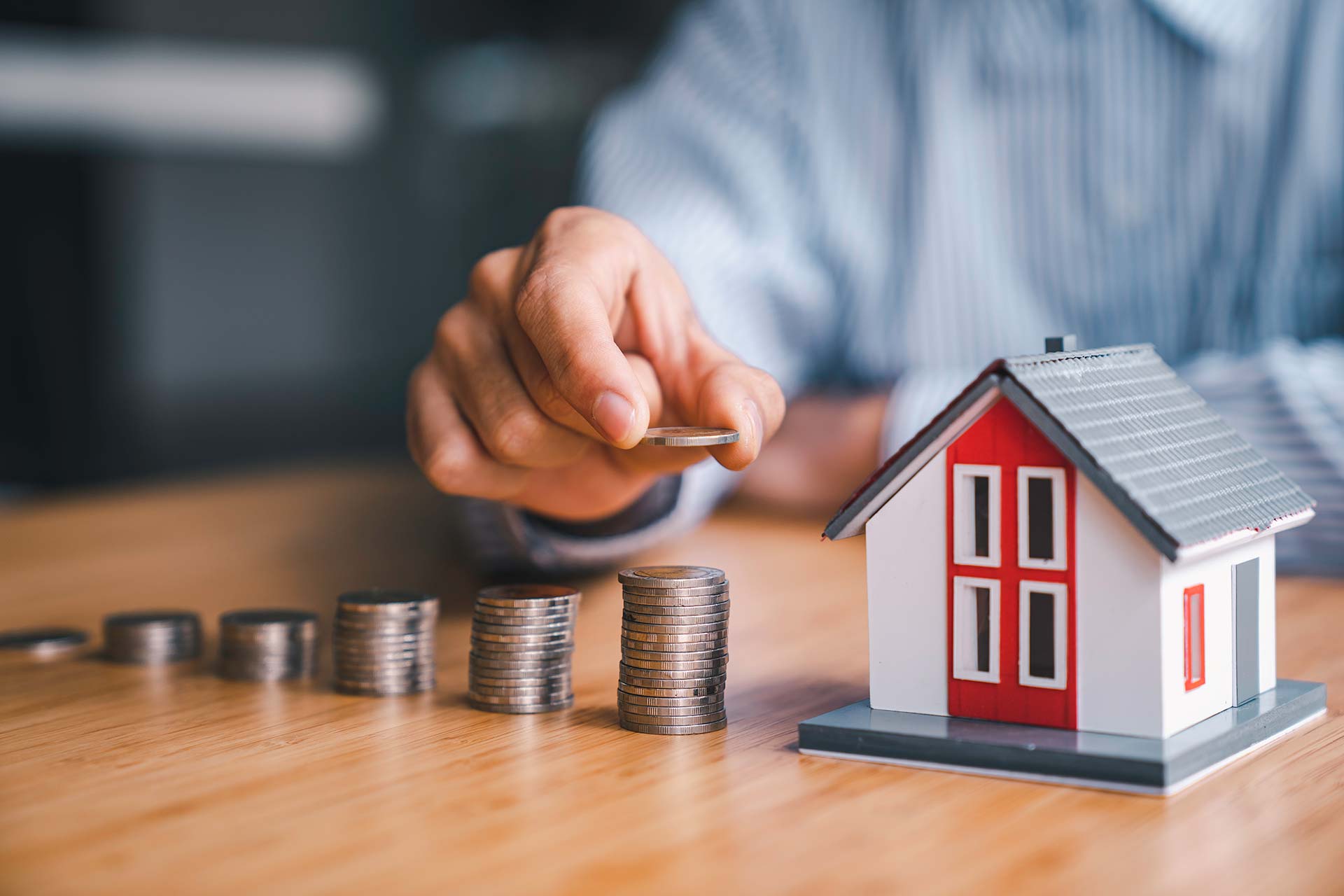 Businessman steps coins with model house