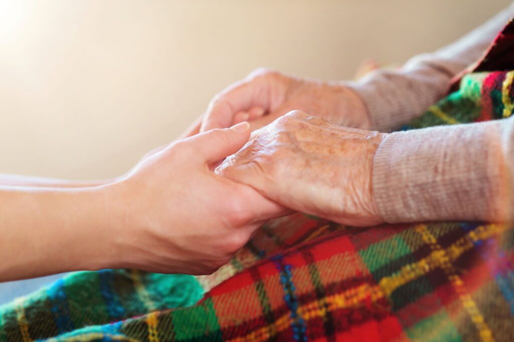 Gentle hand holding of senior woman