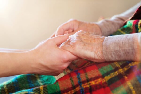 Gentle hand holding of senior woman